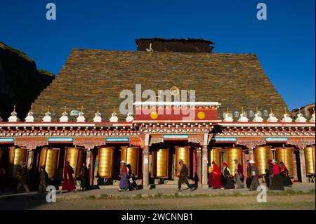 Tibet, Kham, Litang. Nomadi tibetani vicino a Litang. Gente che circonda il monastero con le ruote di preghiera. Foto Stock