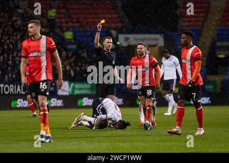 L'arbitro Thomas Bramall mostra un cartellino giallo al Teden Mengi #15 del Luton Town F.C. durante la partita di fa Cup Replay del terzo turno tra Bolton Wanderers e Luton Town al Toughsheet Stadium di Bolton martedì 16 gennaio 2024. (Foto: Mike Morese | mi News) crediti: MI News & Sport /Alamy Live News Foto Stock