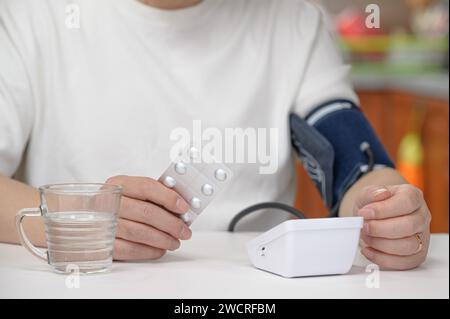 Uomo di mezza età che usa il misuratore della pressione sanguigna Foto Stock