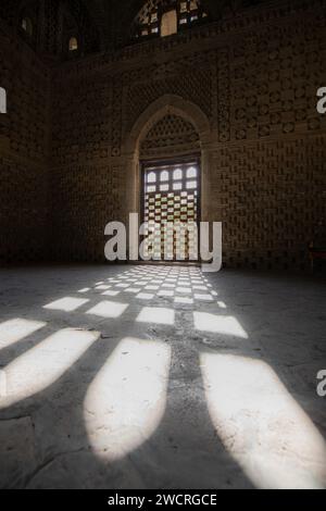 27 GIUGNO 2023, BUKHARA, UZBEKISTAN: Mausoleo Ismail Samani o Mausoleo Samanide interno con l'ombra dalla finestra al tramonto, 9 - 10 cen Foto Stock