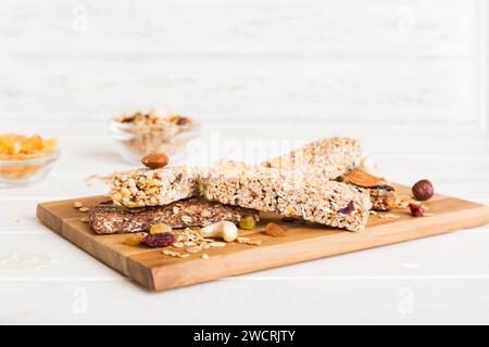 Vari barrette di muesli su sfondo tavolo. Barrette di cereali. Bar per la colazione superfood con avena, noci e frutti di bosco, primo piano. Concetto superfood. Foto Stock