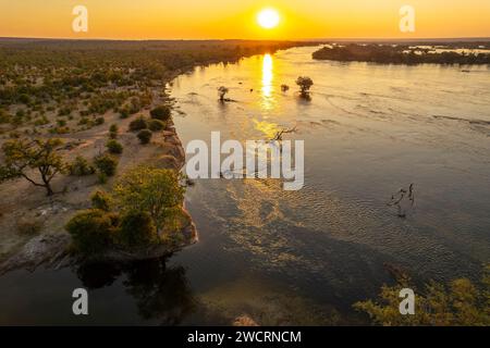 L'alba può essere vista sopra il fiume Zambesi nel Parco nazionale dello Zambesi nello Zimbabwe, le Cascate Vittoria. Foto Stock