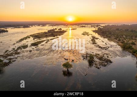 L'alba può essere vista sopra il fiume Zambesi nel Parco nazionale dello Zambesi nello Zimbabwe, le Cascate Vittoria. Foto Stock