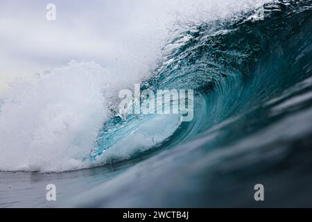 Una vista ravvicinata dinamica di una potente onda oceanica che inizia a creparsi, con spruzzi d'acqua e schiuma chiaramente visibili Foto Stock