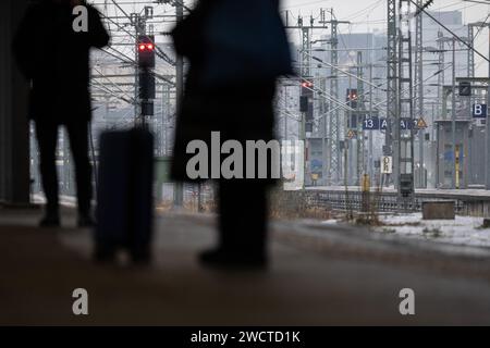 Stoccarda, Germania. 17 gennaio 2024. I passeggeri aspettano un treno alla stazione centrale. Il servizio meteorologico tedesco (DWD) ha avvertito mercoledì mattina di un rischio molto elevato di ghiaccio nero a causa della pioggia ghiacciata. Crediti: Marijan Murat/dpa/Alamy Live News Foto Stock