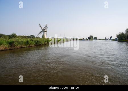 River Thurne e Thurne Mill con una barca a vela Norfolk Wherry in lontananza sulle Norfolk Broads settembre 2023 Foto Stock