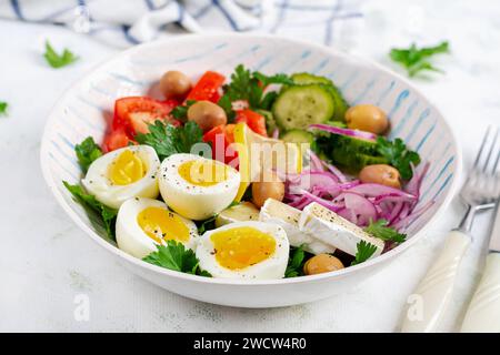 Colazione. Insalata greca e uova sode. Insalata di verdure fresche con pomodoro, cetrioli, olive, rucola e formaggio. Foto Stock