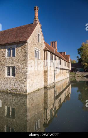Ightham, Kent, Inghilterra. Ightham Mote, un maniero medievale del XIV secolo, che si riflette nelle acque tranquille del suo fossato, autunno. Foto Stock
