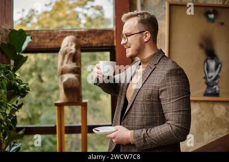 leader aziendale allegro e sofisticato con bicchieri in elegante abito che beve il suo caffè caldo Foto Stock