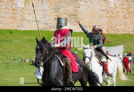 Lincoln, Lincolnshire, Inghilterra. Guerrieri a cavallo che prendono parte a una rievocazione medievale della battaglia sui prati del Castello di Lincoln. Foto Stock