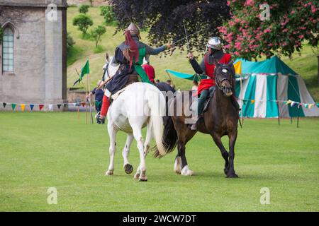 Lincoln, Lincolnshire, Inghilterra. Guerrieri a cavallo che prendono parte a una rievocazione medievale della battaglia sui prati del Castello di Lincoln. Foto Stock