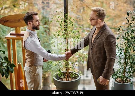 leader aziendali concentrati e attraenti in abiti sofisticati che si mettono in posa insieme mentre lavorano sodo Foto Stock