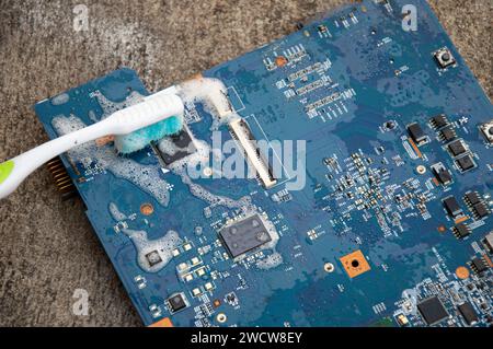 Vista dall'alto. Tecnico che pulisce la scheda madre. computer con soluzione detergente Foto Stock