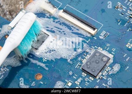 Vista dall'alto. Tecnico che pulisce la scheda madre. computer con soluzione detergente Foto Stock