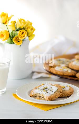 Una porzione di biscotti fatti in casa ai semi di limone con un piatto dietro. Foto Stock