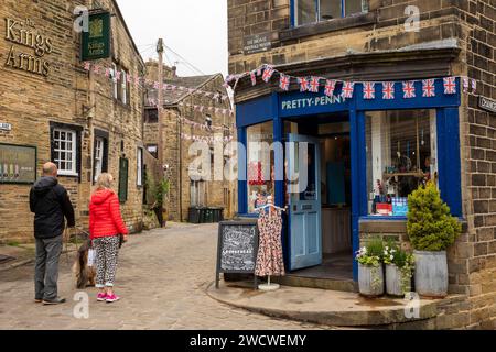 Regno Unito, Inghilterra, Yorkshire, Worth Valley, Haworth, i visitatori all'esterno del negozio di abbigliamento Pretty-Penny all'incrocio con West Lane e Changegate, Foto Stock