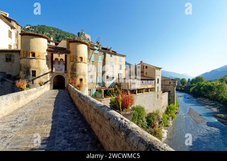 Francia, Alpes de Haute Provence; villaggio di Entrevaux, etichettato Les Plus Beaux Villages de France (i più bei villaggi della Francia), la città medievale, fortificata da Vauban in un'ansa del fiume Var, ingresso alla città medievale, il ponte e la porta reale, cittadella di Vauban sullo sfondo Foto Stock