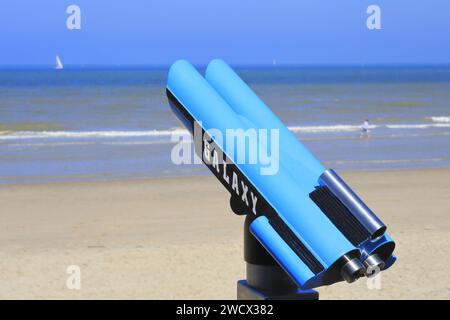 Francia, Nord, dintorni di Dunkerque, Bray-Dunes, spiaggia, binocolo turistico Galaxy con una barca a vela in lontananza Foto Stock