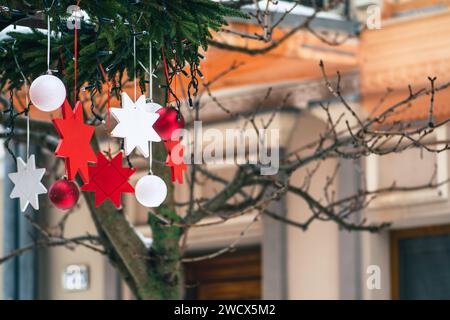 Decorazioni natalizie appese a un albero in un mercato di cibo di strada, bauble natalizi e stelle con luci Foto Stock