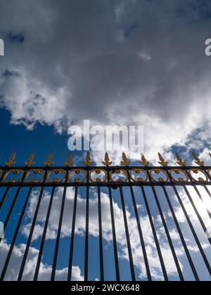 Vista da una recinzione metallica con punte dorate nel cielo di Parigi. Foto Stock