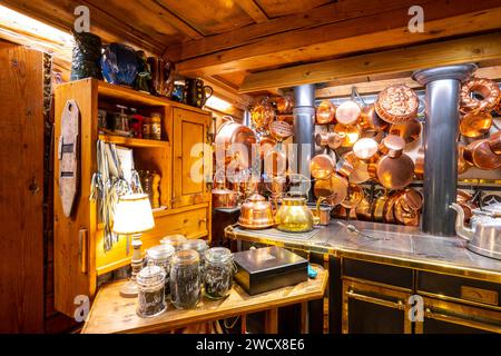 Francia, Haute Savoie, Aravis Massif, Vonezins farm, Thones, una camera per gli ospiti in un decor molto tradizionale e intimo di chalet alpini, pentole di rame e vecchia stufa a legna Foto Stock