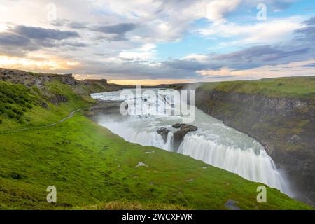 Masse d'acqua cadono a cascata lungo Gullfoss, creando uno spruzzo di nebbia sul bordo. Foto Stock