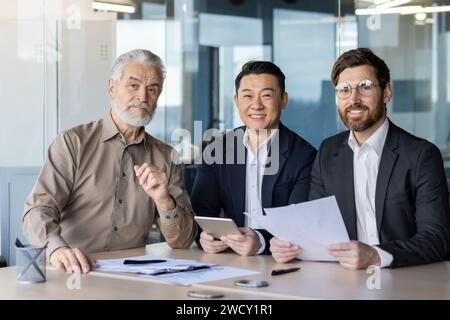 Uomini d'affari multietnici che lavorano insieme in un ufficio, mettendo in mostra lavoro di squadra e professionalità. Foto Stock