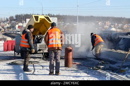 HOSTOMEL, UCRAINA - 17 GENNAIO, 2024 - sono in corso lavori di riparazione sul ponte Hostome, rovinato dall'esercito ucraino, che ha contribuito a fermare l'avanzata e a distruggere una grande colonna di veicoli blindati russi che tentavano di raggiungere la capitale Ucraina durante la battaglia di Kiev nel febbraio 2022, Hostomel, regione di Kiev, Ucraina settentrionale. Il traffico è stato parzialmente ripreso lungo il ponte lungo 134 metri che attraversa il fiume Irpin alla periferia di Hostomel che collega Bucha e Kiev. Foto Stock