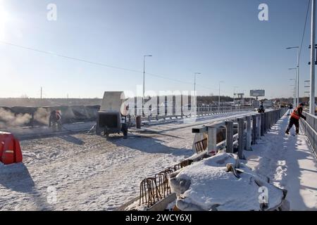 HOSTOMEL, UCRAINA - 17 GENNAIO, 2024 - sono in corso lavori di riparazione sul ponte Hostome, rovinato dall'esercito ucraino, che ha contribuito a fermare l'avanzata e a distruggere una grande colonna di veicoli blindati russi che tentavano di raggiungere la capitale Ucraina durante la battaglia di Kiev nel febbraio 2022, Hostomel, regione di Kiev, Ucraina settentrionale. Il traffico è stato parzialmente ripreso lungo il ponte lungo 134 metri che attraversa il fiume Irpin alla periferia di Hostomel che collega Bucha e Kiev. Foto Stock