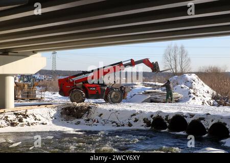 HOSTOMEL, UCRAINA - 17 GENNAIO, 2024 - sono in corso lavori di riparazione sul ponte Hostome, rovinato dall'esercito ucraino, che ha contribuito a fermare l'avanzata e a distruggere una grande colonna di veicoli blindati russi che tentavano di raggiungere la capitale Ucraina durante la battaglia di Kiev nel febbraio 2022, Hostomel, regione di Kiev, Ucraina settentrionale. Il traffico è stato parzialmente ripreso lungo il ponte lungo 134 metri che attraversa il fiume Irpin alla periferia di Hostomel che collega Bucha e Kiev. Foto Stock