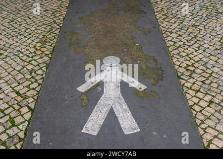 Figura dipinta che mostra il percorso pedonale su una strada acciottolata Foto Stock