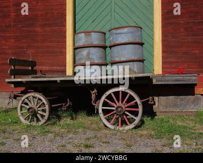 Rustico carro in legno con botti di fronte alla vecchia casa. Foto Stock