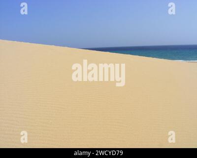 Incontro tra dune di sabbia, oceano e cielo blu sull'isola di Fuerteventura. Foto Stock