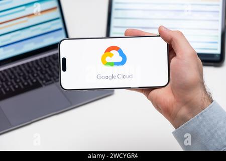 Logo Google Cloud dell'app sullo schermo del telefono cellulare tenuto dall'uomo davanti al laptop e al tablet, dicembre 2023, Praga, Repubblica Ceca Foto Stock