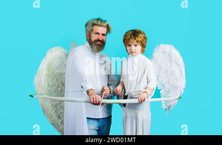 Festa di San Valentino. Bambino e uomo barbuto in costume d'angelo con arco e freccia. Carini angeli di Natale. La festa del padre. Padre e figlio dentro Foto Stock