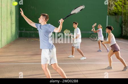 Giovane uomo che gioca frontenis sul campo di pelota all'aperto Foto Stock