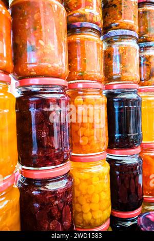 Vista dettagliata di molti vasetti impilati di salse fatte in casa, marmellate e oggetti sottaceto. Presso il principale mercato alimentare locale dell'era sovietica, il Bazar verde. Ad Alma Foto Stock