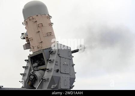 Un sistema di armi Phalanx ravvicinato che lancia dei colpi a bordo della USS Hue City Foto Stock
