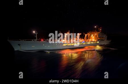 L'oliatore di rifornimento della flotta USNS John Ericsson transita di notte nel Mar dei Coralli. Foto Stock