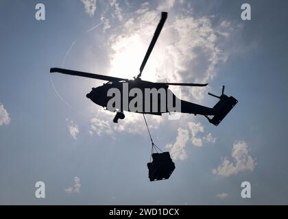 Un elicottero MH-60S Sea Hawk fornisce rifornimenti durante un rifornimento in mare. Foto Stock