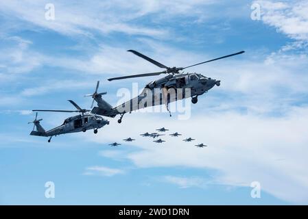 Elicotteri MH-60S Sea Hawk, F/A-18 Super Hornets e un e-2C Hawkeye in volo. Foto Stock