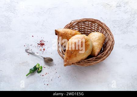 Deliziosa Samsa con agnello e spezie cotte in tandoor su fondo di pietra. Concetto di cucina uzbeka e dell'Asia centrale Foto Stock