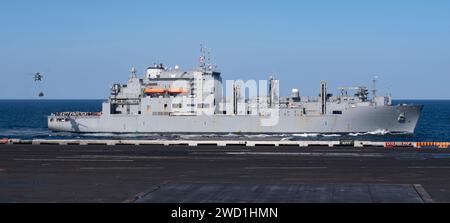 L'USNS Matthew Perry si trova a fianco della portaerei USS Nimitz durante un rifornimento in mare. Foto Stock