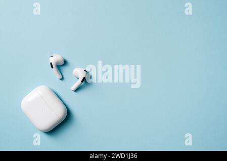 Cuffie wireless e scatola di ricarica, fotografate lasciando spazio vuoto sul lato destro della foto Foto Stock