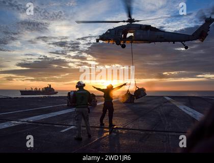 La USS Carl Vinson effettua un rifornimento verticale in mare con un oliatore di rifornimento della flotta USNS Yukon. Foto Stock