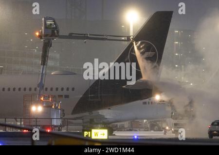 18 gennaio 2024, Assia, Francoforte sul meno: Un aereo della Lufthansa viene sghiacciato. Anche molti voli all'aeroporto di Francoforte sono stati cancellati giovedì a causa del continuo rischio di condizioni di ghiaccio. Foto: Lando Hass/dpa Foto Stock