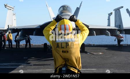 U.S. Navy Aviation Boatswain's Mate dirige un aereo sul ponte di volo della USS Nimitz. Foto Stock