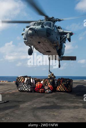 I Marines attaccano pallet di forniture a un elicottero MH-60S Seahawk durante un rifornimento verticale. Foto Stock