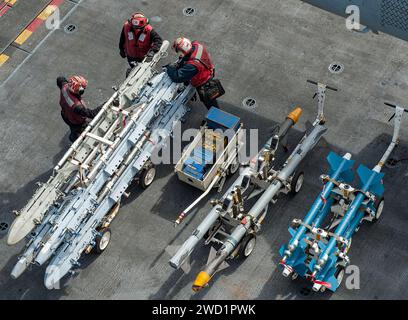 I marinai proteggono e trasportano ordigni a bordo della portaerei USS George H.W. Bush. Foto Stock