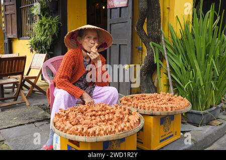 Vietnam: Un venditore dimostra come utilizzare i fischi dei giocattoli di ceramica che sta vendendo, Tran Phu Street, Hoi An. La piccola ma storica città di Hoi An si trova sul fiume Thu Bon a 30 km a sud di Danang. Durante il tempo dei signori Nguyen (1558 - 1777) e anche sotto i primi imperatori Nguyen, Hoi An - allora conosciuto come Faifo - era un porto importante, visitato regolarmente da navi provenienti dall'Europa e da tutto l'Oriente. Foto Stock